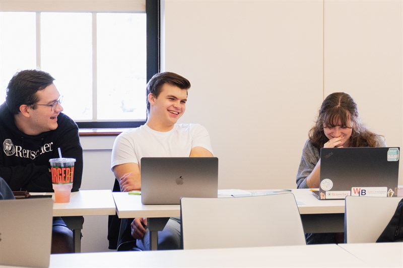 Three business students in front of computers